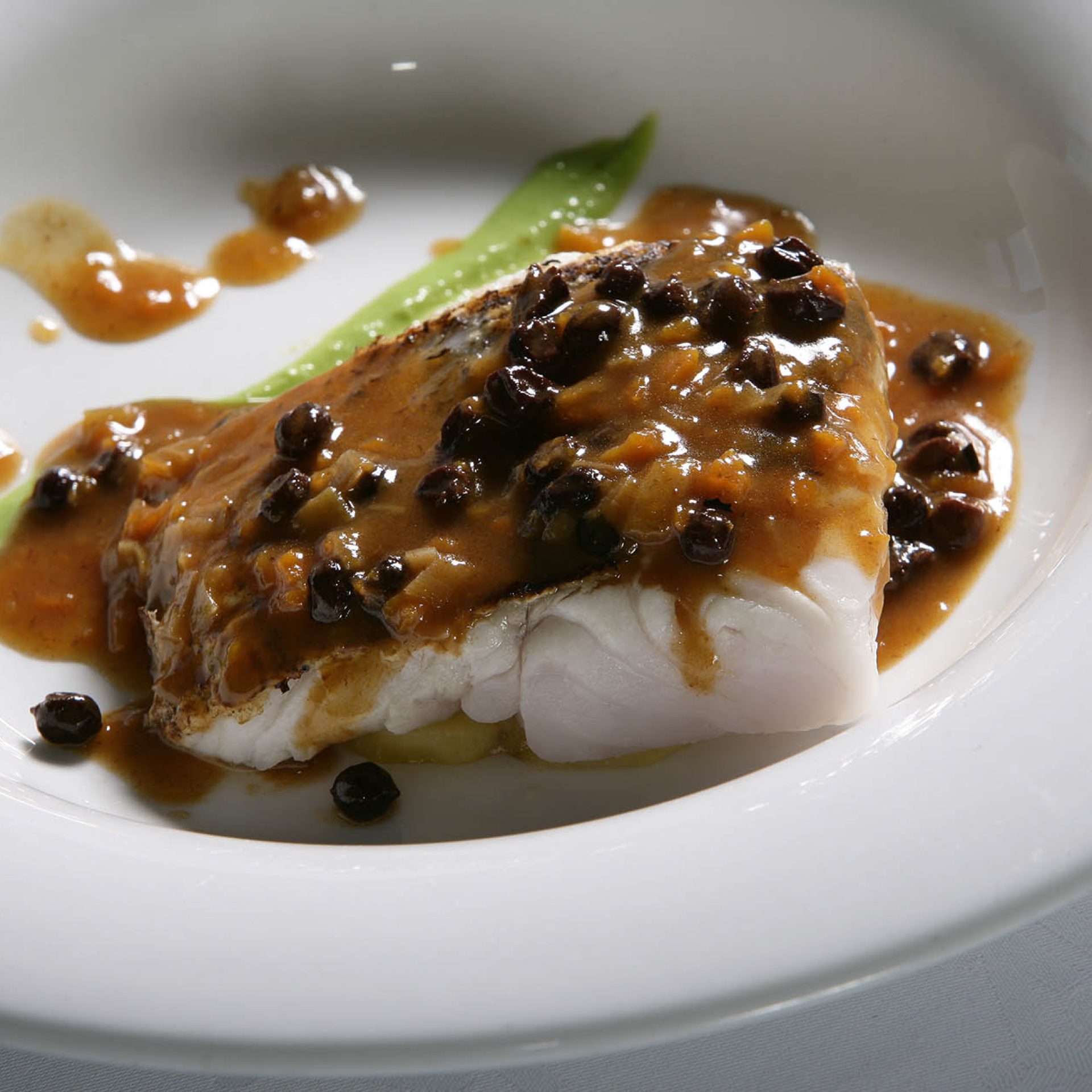 Taco de merluza en salsa mozárabe de miel y pasas.Parador de Ja